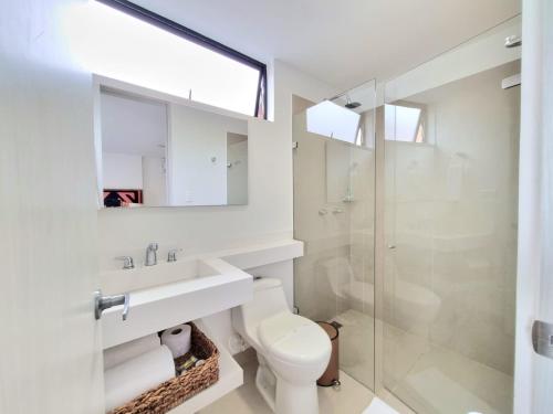 a bathroom with a toilet and a sink and a shower at Origen Local Suites in Medellín