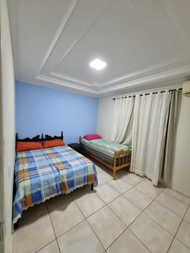 1 Schlafzimmer mit 2 Betten in einem Zimmer mit blauen Wänden in der Unterkunft Casa a 500 metros da praia em balneário piçarras in Piçarras