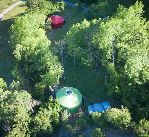 an overhead view of a green building in the trees at Eco-hôtel et Yourtes du Mercantour in Guillaumes