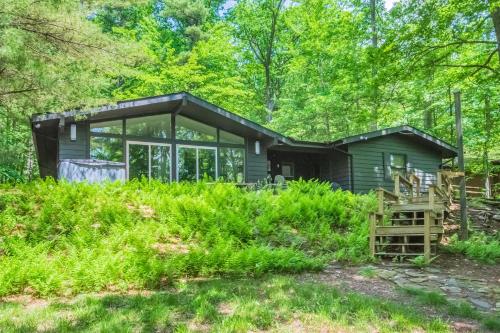 a small green cabin in the woods with trees at Waltzing Matilda in Swanton