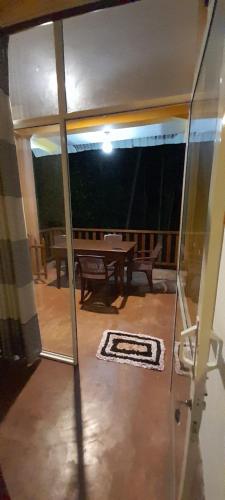 a glass door leading to a patio with a table at Sinharaja Vini Villa in Deniyaya
