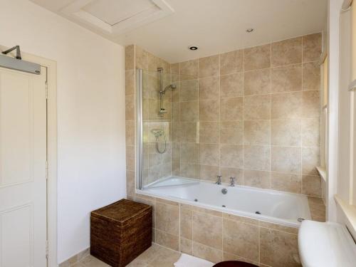 a bathroom with a tub and a shower and a sink at Green Craig in Aberlady