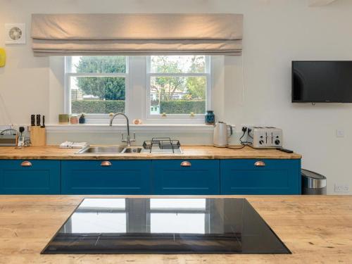 a blue kitchen with a sink and a window at Marine House in Gullane