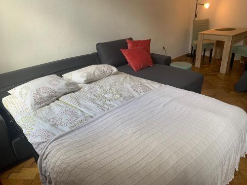 een slaapkamer met een bed en een bank bij Homelike City Apartment in Wenen