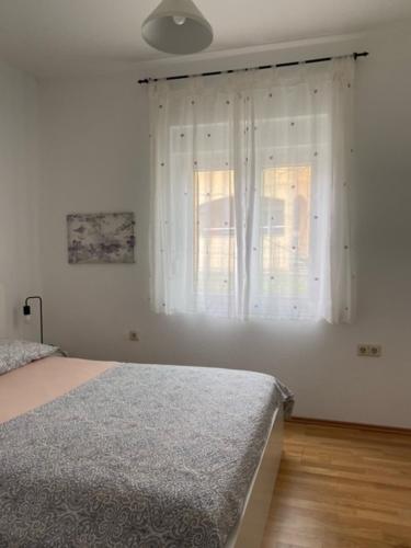 una camera bianca con un letto e una finestra di Apartment M & M a Spalato (Split)