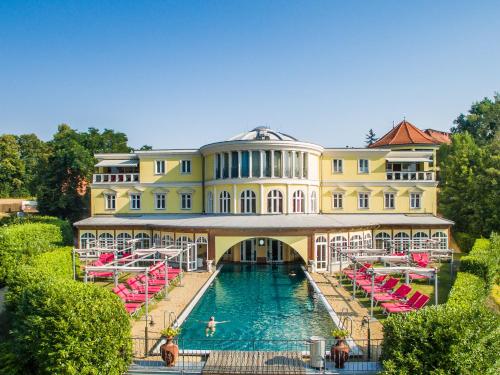 a large building with a pool in front of it at Hotel BEI SCHUMANN in Kirschau