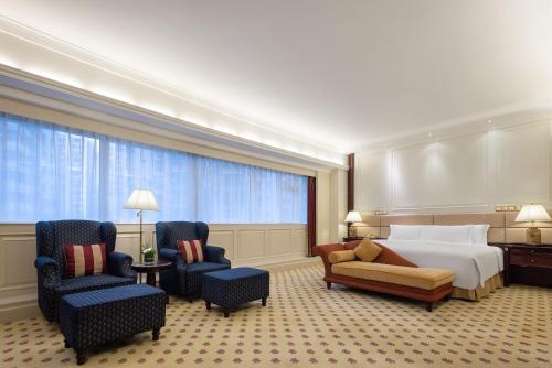a hotel room with a bed and two chairs at Crowne Plaza Hotel & Suites Landmark Shenzhen by IHG - Nearby Luohu Border, Indoor heated swimming pool, Complimentary Welcome Drink in Shenzhen