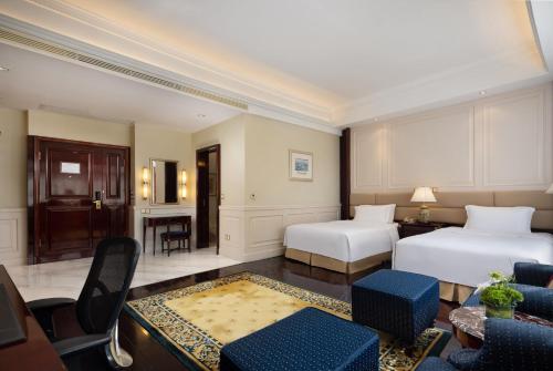 a hotel room with two beds and a table and chairs at Crowne Plaza Hotel & Suites Landmark Shenzhen by IHG - Nearby Luohu Border, Indoor heated swimming pool, Complimentary Welcome Drink in Shenzhen