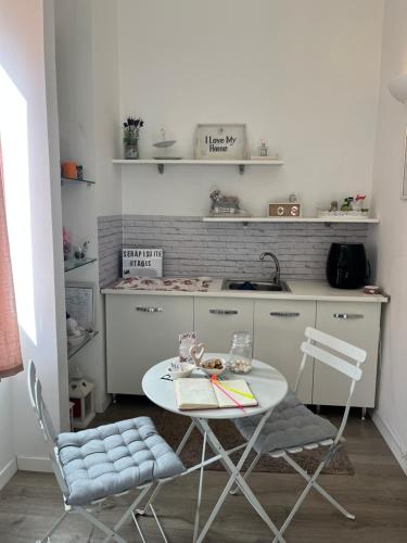 uma pequena cozinha com uma mesa e duas cadeiras em Serapisuite em Pozzuoli