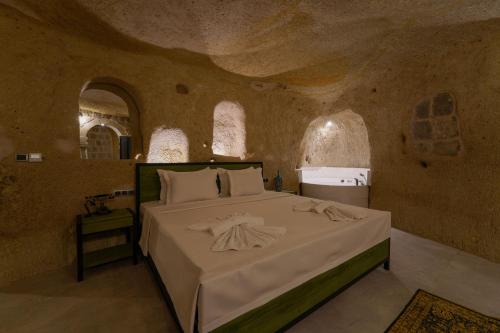 a bedroom with a large bed in a stone room at The Niche Cave Hotel in Goreme