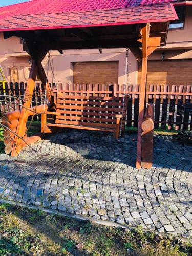 a bench under a gazebo in front of a house at Катерина in Chynadiyovo