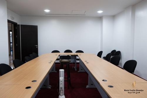 a conference room with a long table and chairs at Lalla Doudja Hotel in Alger