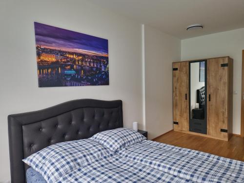 - une chambre avec un lit et une photo sur le mur dans l'établissement Vltava apartments, à Prague