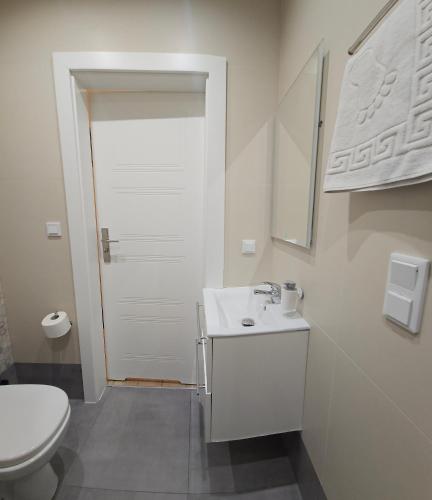 a white bathroom with a sink and a toilet at WILLA BAJLAND in Warsaw