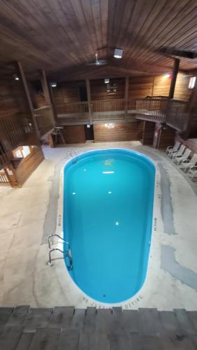 a large pool in a building with a wooden ceiling at Lumberjack Inn in Hayward
