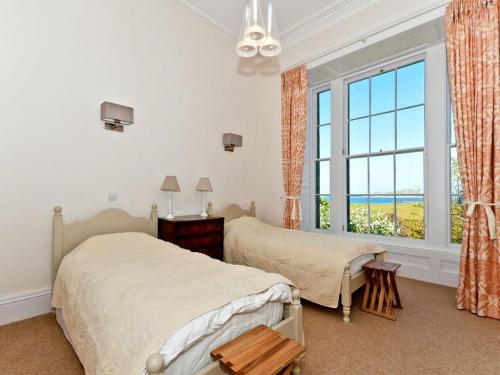 two beds in a bedroom with a large window at Inchgarry Court in North Berwick