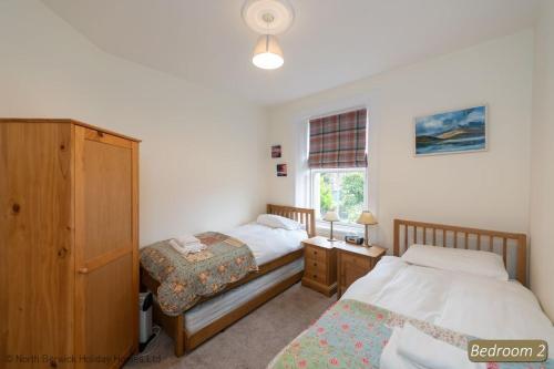 1 dormitorio con 2 camas y ventana en Hopetoun Cottage, en Gullane