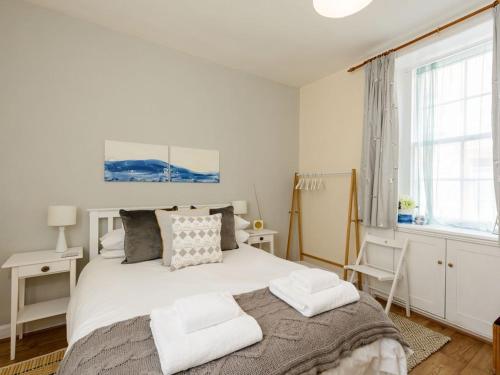 a bedroom with a bed with two towels on it at Kittiwake in North Berwick