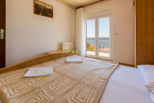 a bedroom with a large bed with a large window at Apartments Matilda in Dramalj