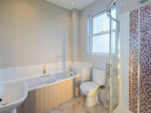 北貝里克的住宿－Craigleith Lodge，浴室配有卫生间、浴缸和水槽。
