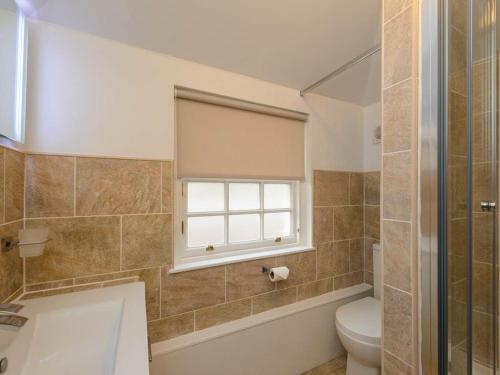 a bathroom with a toilet and a window at Curlew in North Berwick