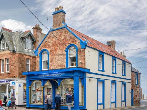 a blue and white building on the corner of a street at Curlew in North Berwick