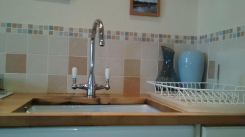 a kitchen counter with a sink with a sink at Harbourside Cottage in North Berwick