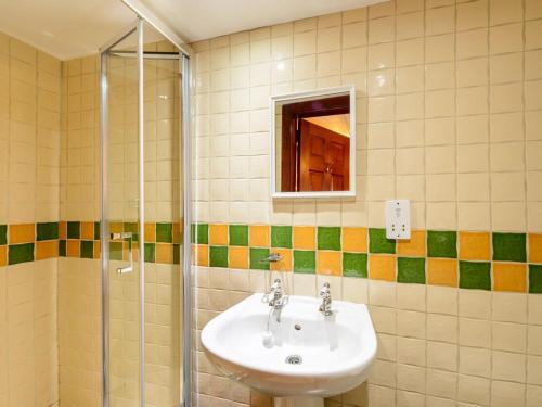 uma casa de banho com um lavatório e uma cabina de duche em vidro. em Harmony Undercroft em North Berwick
