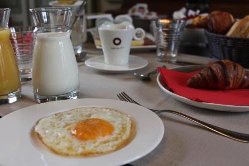a plate with an egg on a table with milk at Amaryllis Hotel Veurne in Veurne