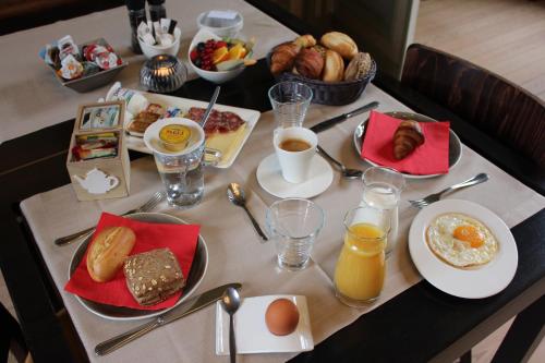 a table with breakfast foods and drinks on it at Amaryllis Hotel Veurne in Veurne