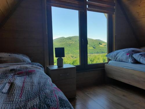 a bedroom with a bed and a window with a view at Domki Dwa in Limanowa