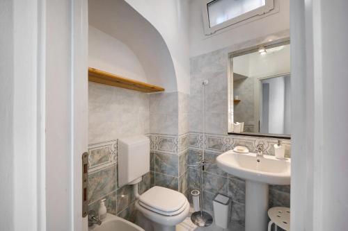 a bathroom with a toilet and a sink and a mirror at The Family Free Parking in Alassio in Alassio