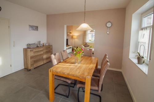 a dining room with a wooden table and chairs at Ferienhaus Rena in Krummhörn