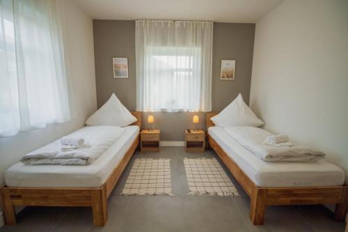 two twin beds in a room with a window at Ferienhaus Rena in Krummhörn