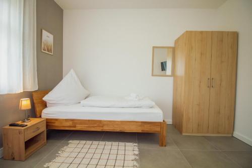 a bedroom with a bed and a wooden cabinet at Ferienhaus Rena in Krummhörn