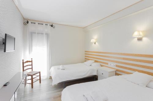 Cette chambre comprend deux lits et un bureau. dans l'établissement Casa Lili, à Moraira