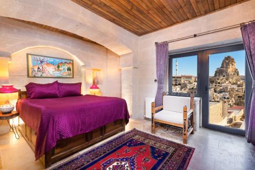 a bedroom with a purple bed and a window at Cappadocia hotel Megaron cave in Ortahisar
