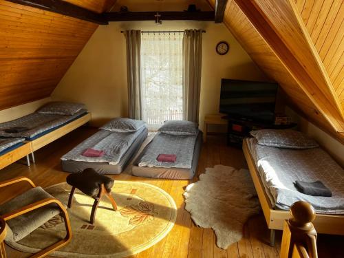 a room with three beds and a glass table at Samsolandia Willa Falsztyn in Falsztyn