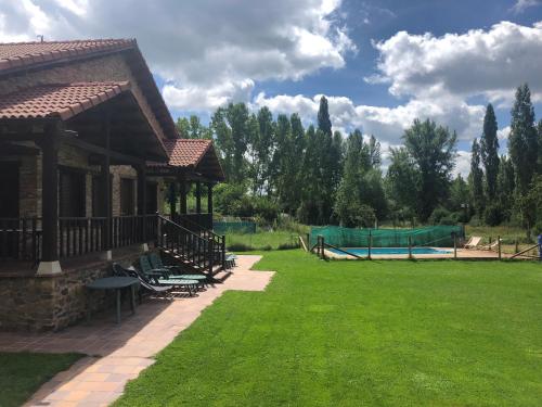 un gran patio con una casa y una piscina en Casa de turismo rural San Martín de valdetuejar, en San Martín de Valdetuéjar