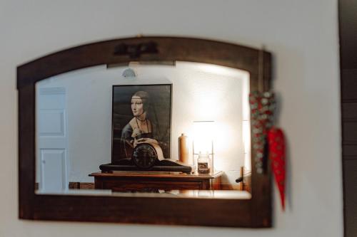 a mirror in a room with a picture of a man at Dom Gościnny Tatra Nova in Długopole-Zdrój