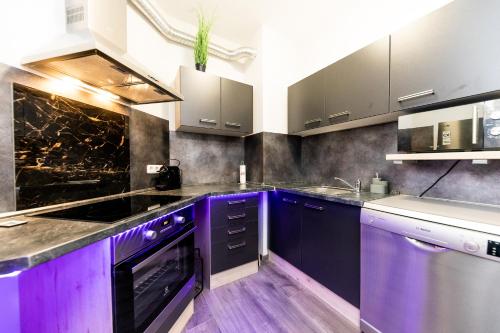 eine Küche mit lila Schränken und einem Waschbecken in der Unterkunft H & A Suite Gozsdu - THE 1001 NIGHTS SUITE in Budapest