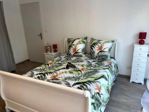 a bed with a comforter with a cat sitting on it at Un moment de détente Maison avec balnéothérapie . in Prades