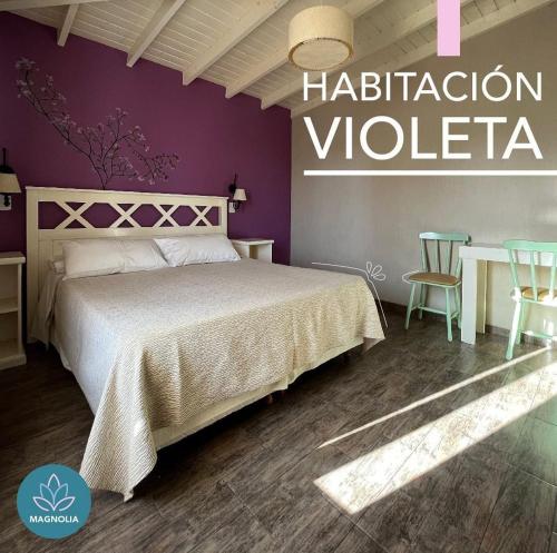 a bedroom with a bed and a table with chairs at Hostería Magnolia in Villa Gesell