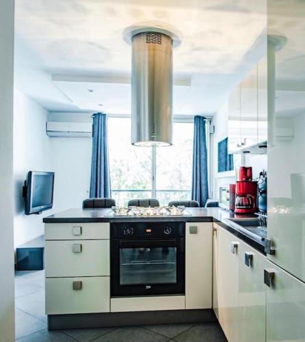 - une cuisine avec une cuisinière dans l'établissement Bleu soleil * Clim * Parking privé * Chambre * Terrasse, à La Grande Motte