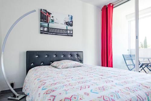 une chambre avec un lit et un rideau rouge dans l'établissement Bleu soleil * Clim * Parking privé * Chambre * Terrasse, à La Grande Motte
