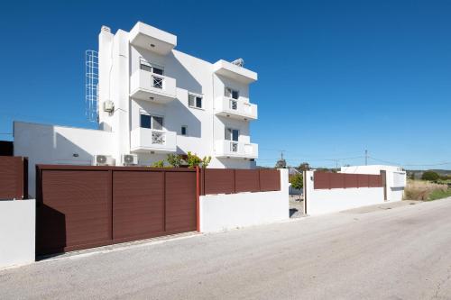 a white building with a brown garage door at Casa Marinella in Gennadi