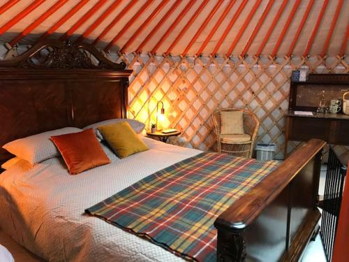 una camera con un letto in una stanza con tetto arancione di Gilfach Gower Farm Luxury Yurt with Hot Tub ad Ammanford