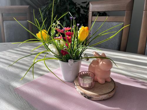 a table with a vase of flowers on a table at Pokoje u Hani - sauna, balia z hydromasażem in Bukowina Tatrzańska