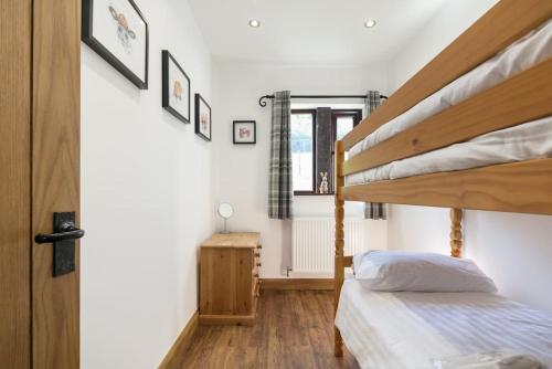 a bedroom with two bunk beds and a window at NEW BARN CONVERSION WITH PRIVATE HOT TUB in Halifax