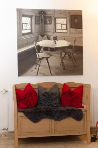 a living room with a couch with red pillows at Pension Haus in der Sonne in Fieberbrunn